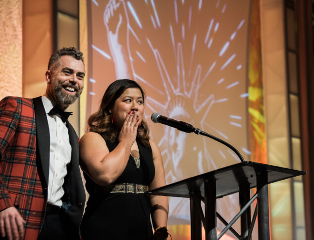 Two people on stage at ACLU Liberty Dinner 2019 with shocked and happy sentiments on their faces