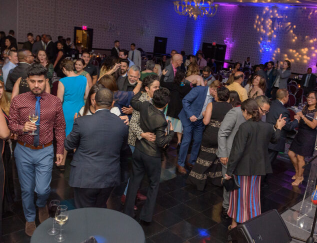People dancing and enjoying drinks on a crowded and lively dance floor