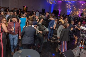 People dancing and enjoying drinks on a crowded and lively dance floor