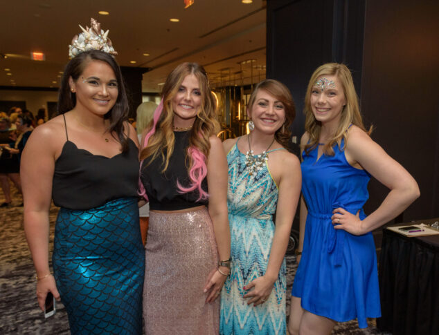 GlamHer staff posing while dressed in mermaid-themed attire